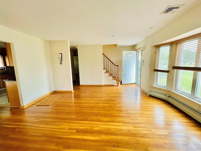 24 Gaymor Ln, Commack, NY 11725 - unfurnished room with light wood-style floors, stairway, baseboards, and a baseboard heating unit