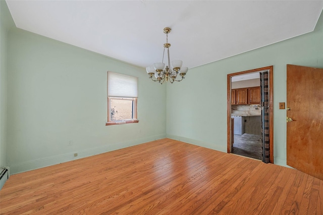 155 Carman Ave, East Rockaway, NY 11518 - empty room featuring a chandelier, wood finished floors, baseboards, and a baseboard radiator