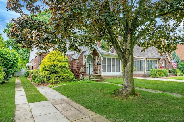 155 Carman Ave, East Rockaway, NY 11518 - view of front of property featuring brick siding, a front yard, and a sunroom