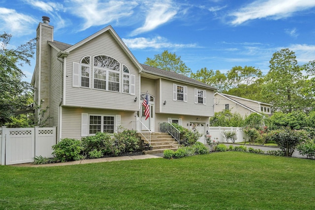 14 Arlington St, Patchogue, NY 11772 - raised ranch with a chimney, an attached garage, and driveway
