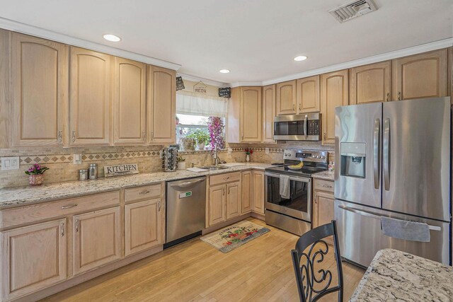 14 Arlington St, Patchogue, NY 11772 - kitchen with appliances with stainless steel finishes, light brown cabinetry, light wood-style flooring, tasteful backsplash, and light stone countertops