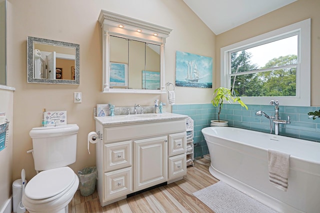14 Arlington St, Patchogue, NY 11772 - full bath with wood finished floors, lofted ceiling, a freestanding bath, toilet, and tile walls