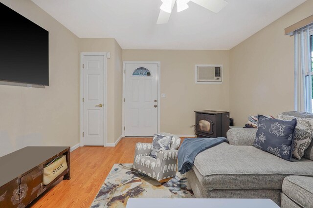 14 Arlington St, Patchogue, NY 11772 - living area featuring a wood stove, light wood finished floors, a ceiling fan, and baseboards