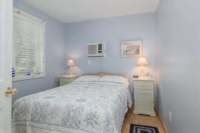 25 Cottage Rd, Baiting Hollow, NY 11933 - bedroom featuring wood finished floors, a wall mounted AC, and baseboards