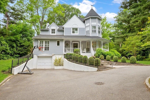 57 Harbor Park Dr, Centerport, NY 11721 - victorian house with a porch, asphalt driveway, a garage, roof with shingles, and a chimney