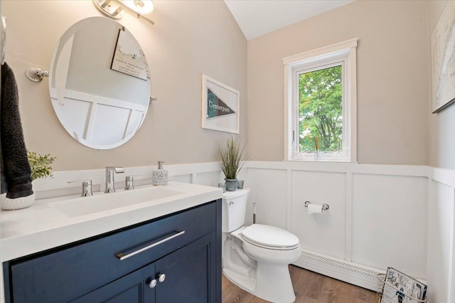 57 Harbor Park Dr, Centerport, NY 11721 - bathroom featuring a baseboard radiator, toilet, vanity, wainscoting, and wood finished floors