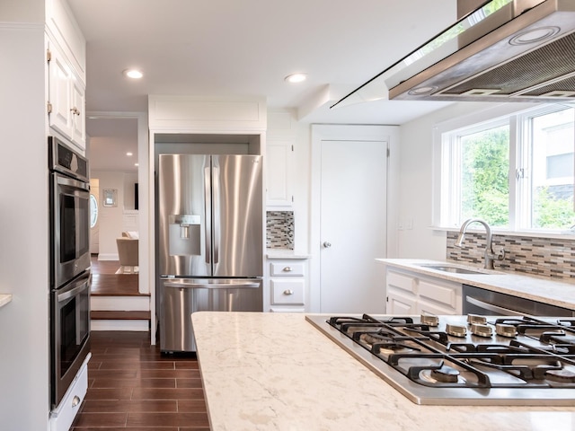 62 Webster Ave, Manhasset, NY 11030 - kitchen featuring appliances with stainless steel finishes, range hood, white cabinetry, dark wood-type flooring, and tasteful backsplash