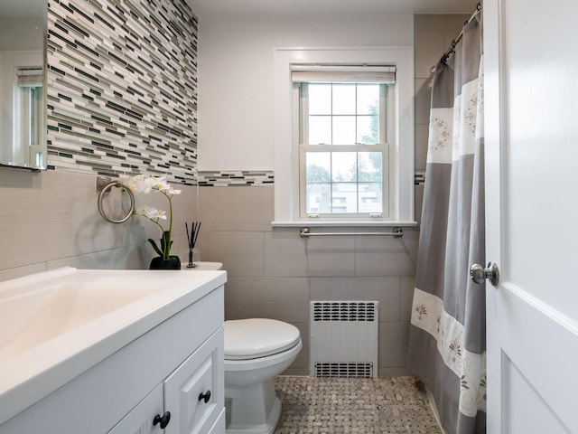 62 Webster Ave, Manhasset, NY 11030 - bathroom featuring tile walls, radiator, vanity, and decorative backsplash