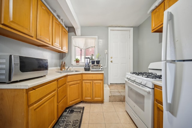 1304 Waring Ave, Bronx, NY 10469 - kitchen featuring white appliances, light countertops, a sink, light tile patterned floors, and brown cabinetry