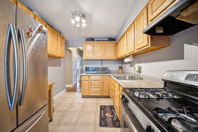 1304 Waring Ave, Bronx, NY 10469 - kitchen featuring appliances with stainless steel finishes, under cabinet range hood, a sink, light tile patterned floors, and light countertops