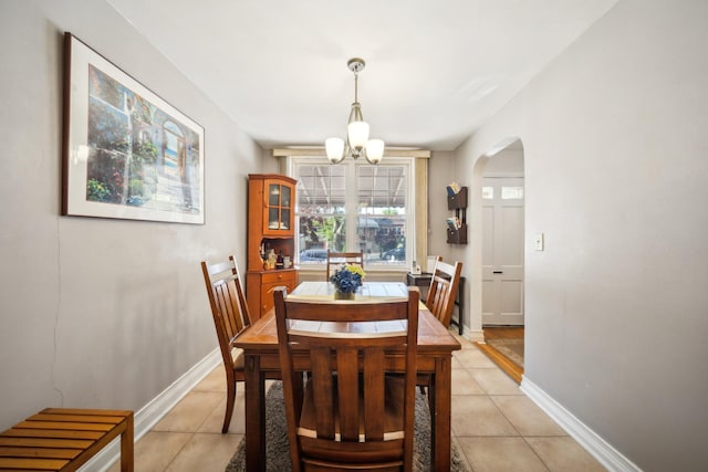 1304 Waring Ave, Bronx, NY 10469 - dining area with light tile patterned floors, arched walkways, a chandelier, and baseboards