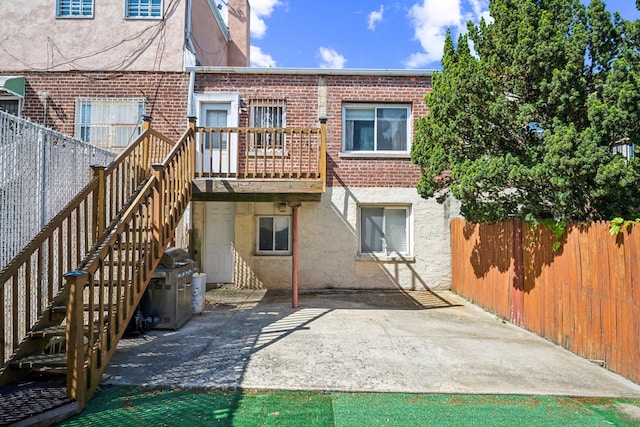 1304 Waring Ave, Bronx, NY 10469 - rear view of property featuring brick siding, a patio, stairway, and a chimney