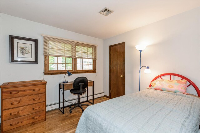 32 Lower Cross, Shoreham, NY 11786 - bedroom featuring baseboard heating and wood finished floors
