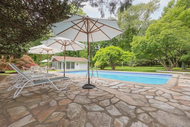 211 N Little Tor Rd, New City, NY 10956 - swimming pool with a patio area, an exterior structure, an outbuilding, a lawn, and view of wooded area