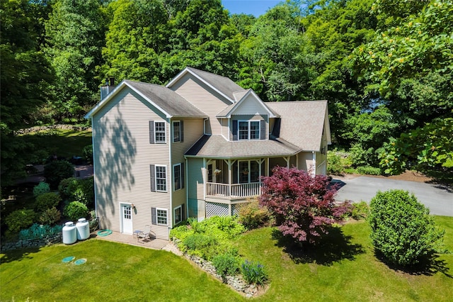 41 Mountain Brook Dr, Cold Spring, NY 10516 - view of front of home with a front lawn, a chimney, covered porch, driveway, and a forest view