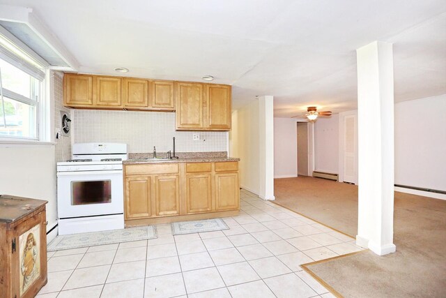 173 Massachusetts Ave, Congers, NY 10920 - kitchen featuring white gas stove, a baseboard heating unit, ceiling fan, backsplash, and a sink