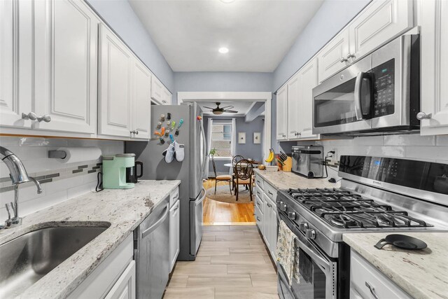 120 E Hartsdale Unit 3L, Hartsdale, NY 10530 - kitchen featuring appliances with stainless steel finishes, a sink, ceiling fan, white cabinets, and backsplash