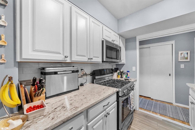 120 E Hartsdale Unit 3L, Hartsdale, NY 10530 - kitchen featuring appliances with stainless steel finishes, white cabinets, tasteful backsplash, and light stone countertops