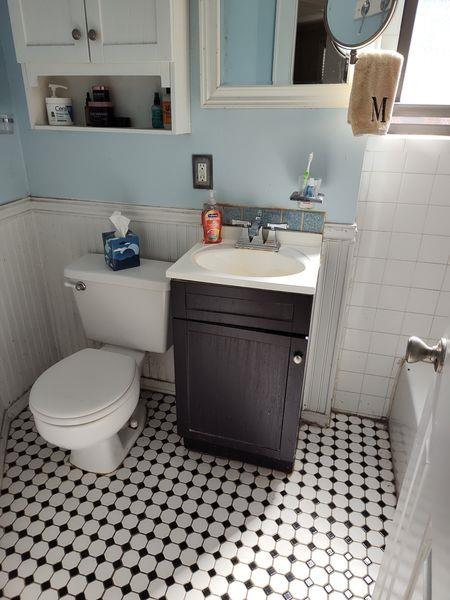 bathroom featuring toilet, vanity, a wainscoted wall, tile patterned flooring, and a bath