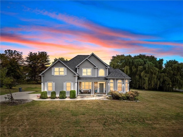 2 Fieldstone Ct, Highland, NY 12528 - back of property at dusk featuring covered porch, a yard, and roof with shingles