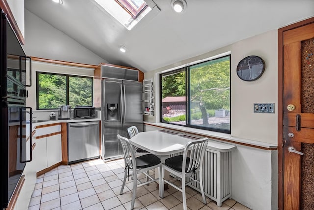 1670 Baptist Church Rd, Yorktown Heights, NY 10598 - kitchen featuring appliances with stainless steel finishes, a skylight, lofted ceiling, light countertops, and light tile patterned floors