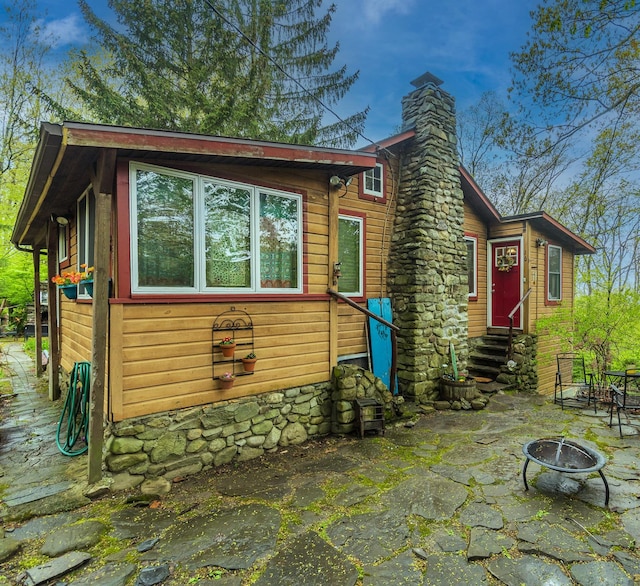 16 Arbor Trl, Monroe, NY 10950 - view of front of property featuring entry steps, a fire pit, a chimney, and a patio