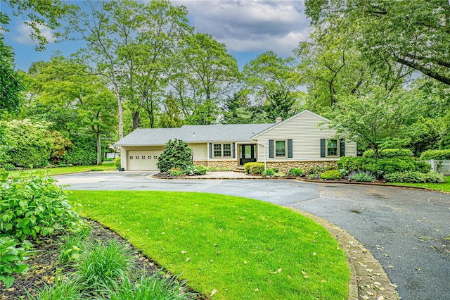 1 Idle Day Dr, Centerport, NY 11721 - view of front of home with driveway, stone siding, a garage, a front lawn, and view of scattered trees