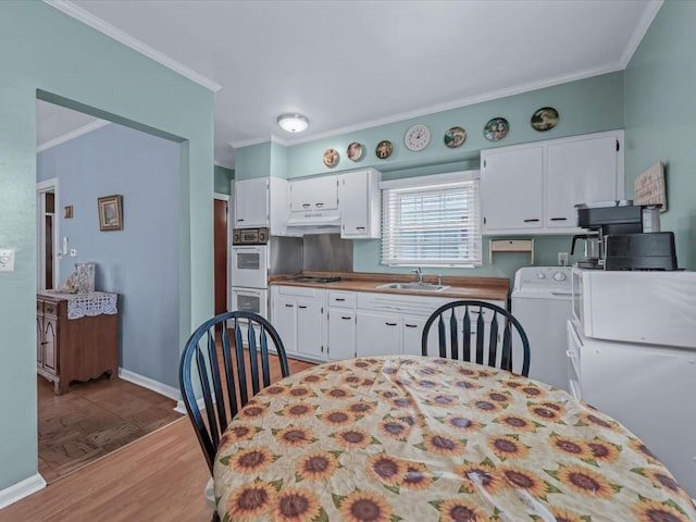 1311 154th St, Beechhurst, NY 11357 - kitchen featuring washer / dryer, a sink, crown molding, white appliances, and white cabinets
