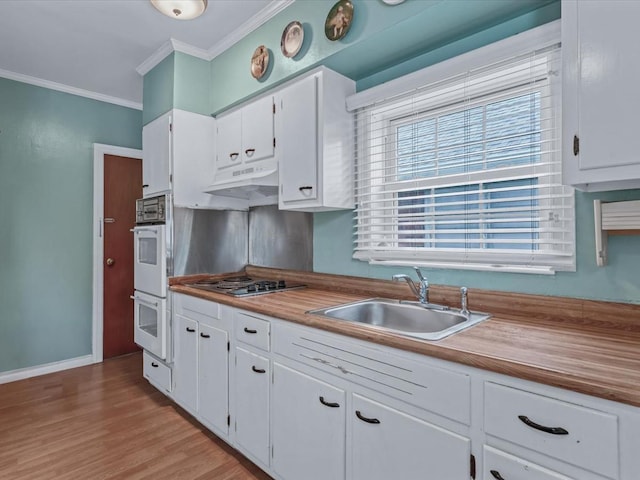 1311 154th St, Beechhurst, NY 11357 - kitchen with stainless steel electric cooktop, crown molding, under cabinet range hood, a sink, and white cabinets