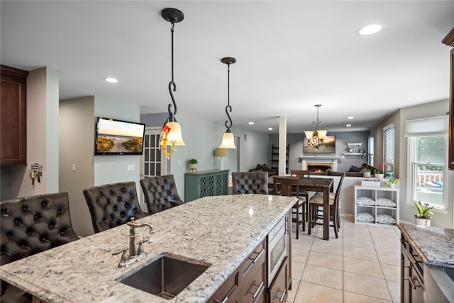2 Old Brookville Ct, Manorville, NY 11949 - kitchen featuring recessed lighting, a lit fireplace, open floor plan, pendant lighting, and light tile patterned floors