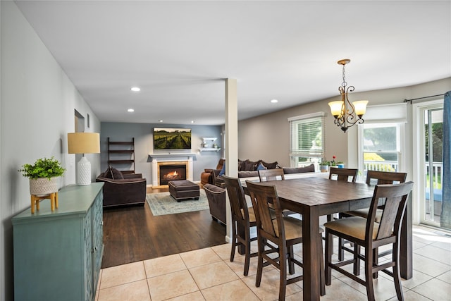2 Old Brookville Ct, Manorville, NY 11949 - dining space with a warm lit fireplace, light tile patterned flooring, recessed lighting, and a chandelier