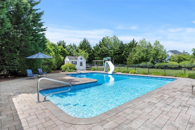 2 Old Brookville Ct, Manorville, NY 11949 - view of swimming pool with a water slide, a patio, and an outbuilding