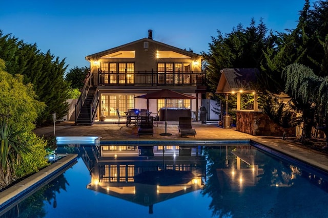 135 Ocean Ave, Massapequa, NY 11758 - back of house featuring a hot tub, stairs, a patio area, stucco siding, and an outdoor pool