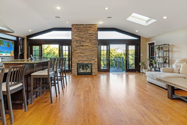 135 Ocean Ave, Massapequa, NY 11758 - bar area with vaulted ceiling, light wood-type flooring, a skylight, a fireplace, and recessed lighting