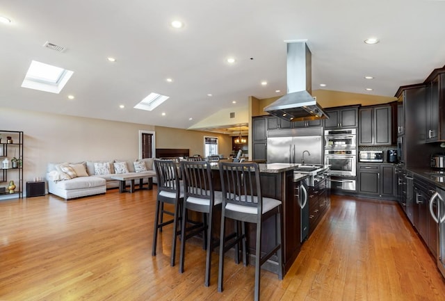135 Ocean Ave, Massapequa, NY 11758 - kitchen with island range hood, stainless steel appliances, an island with sink, lofted ceiling, and open floor plan