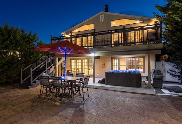 135 Ocean Ave, Massapequa, NY 11758 - back of house at night featuring a patio, stucco siding, and a balcony