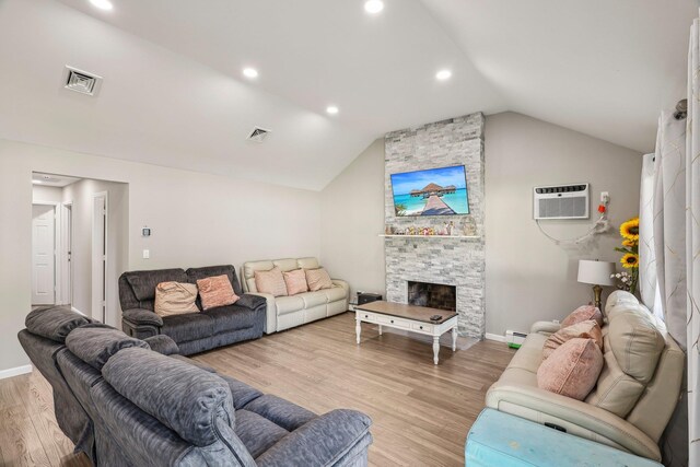 70 Propose Rd, Shirley, NY 11967 - living room with lofted ceiling, a wall mounted AC, light wood finished floors, baseboards, and a stone fireplace
