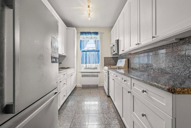 1681 Brooklyn Ave, Brooklyn, NY 11210 - kitchen with stainless steel appliances, radiator, backsplash, baseboards, and white cabinetry