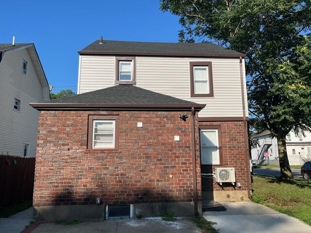 21 James Ll Burrell Ave, Hempstead, NY 11550 - view of property exterior with a cooling unit, roof with shingles, and brick siding