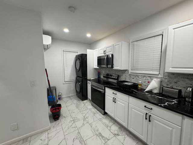 21 James Ll Burrell Ave, Hempstead, NY 11550 - kitchen with stainless steel appliances, stacked washing machine and dryer, light marble finish flooring, dark countertops, and white cabinets