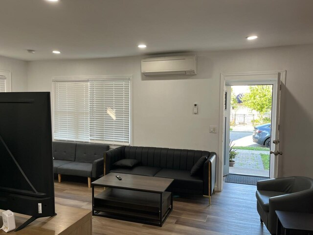 21 James Ll Burrell Ave, Hempstead, NY 11550 - living area with an AC wall unit, wood finished floors, and recessed lighting