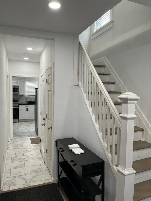 21 James Ll Burrell Ave, Hempstead, NY 11550 - stairs featuring marble look tiles and recessed lighting