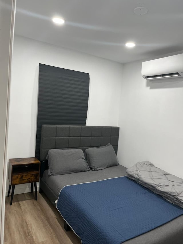 21 James Ll Burrell Ave, Hempstead, NY 11550 - bedroom with a wall unit AC, light wood-type flooring, and recessed lighting