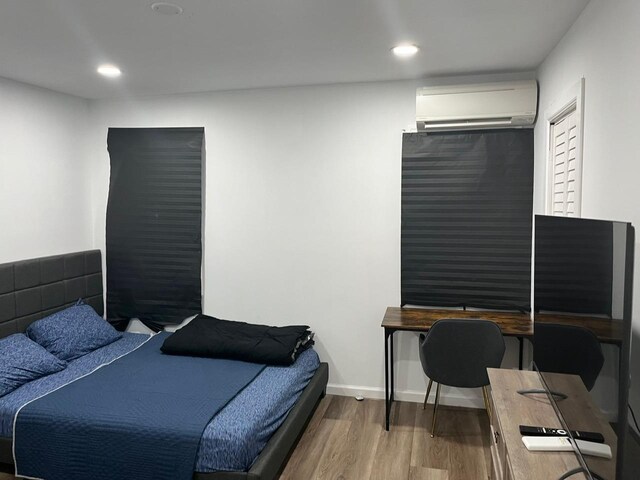 21 James Ll Burrell Ave, Hempstead, NY 11550 - bedroom featuring a wall mounted AC, wood finished floors, recessed lighting, and an office area
