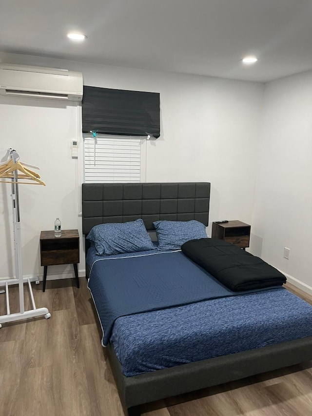 21 James Ll Burrell Ave, Hempstead, NY 11550 - bedroom featuring a wall mounted air conditioner, wood finished floors, recessed lighting, and baseboards