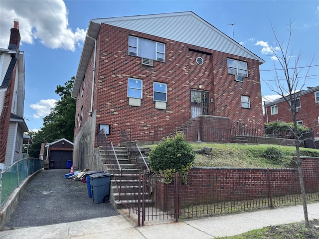 2110 Light St, Bronx, NY 10466 - view of property exterior with brick siding, an outdoor structure, a garage, and asphalt driveway