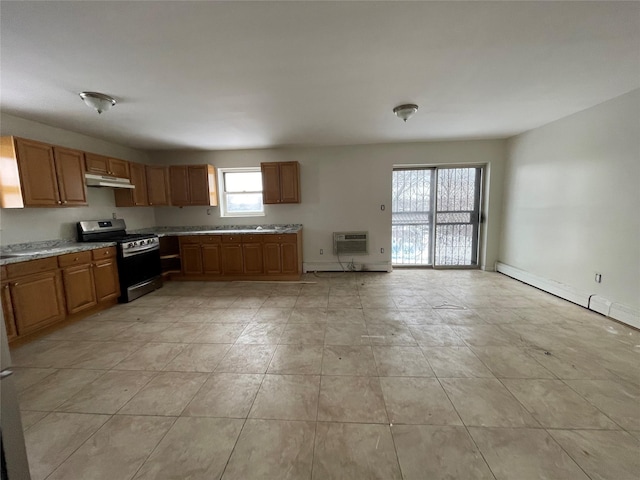 2110 Light St, Bronx, NY 10466 - kitchen with gas range, under cabinet range hood, brown cabinetry, baseboards, and a wall mounted air conditioner