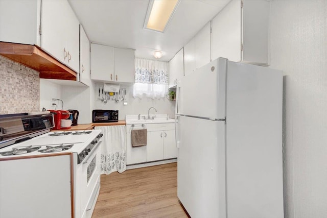 611 Clarence Ave, Bronx, NY 10465 - kitchen featuring white appliances, white cabinets, light countertops, and light wood-style floors