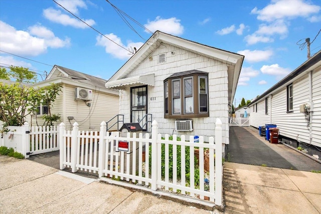 611 Clarence Ave, Bronx, NY 10465 - shotgun-style home featuring a fenced front yard, a wall mounted AC, and a gate
