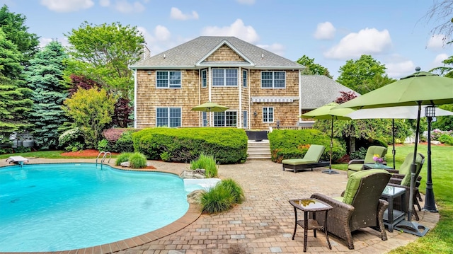 1260 Water Ter, Southold, NY 11971 - back of house with a shingled roof, a patio, and an outdoor pool